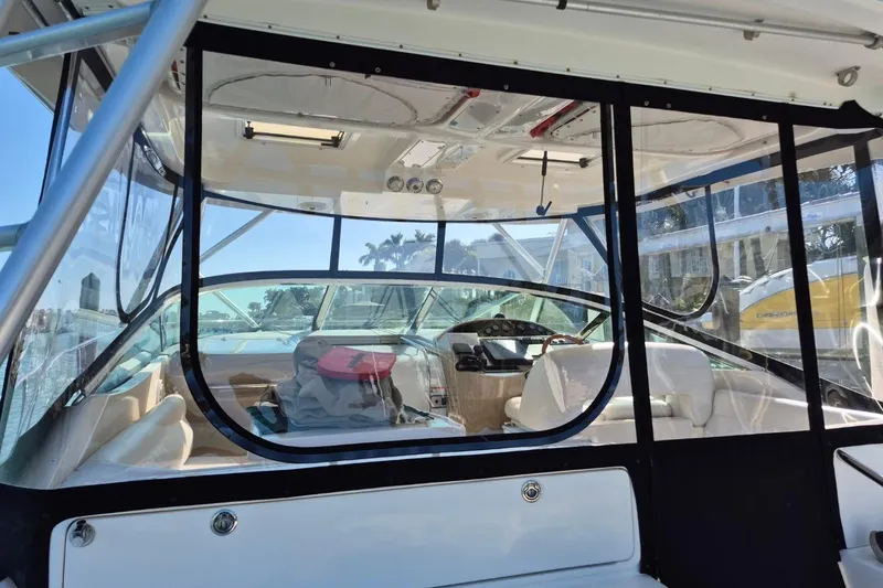 Slide: The Image of 2004 Riviera 4000 Offshore boat interior with helm, seating, and clear enclosure. - 76