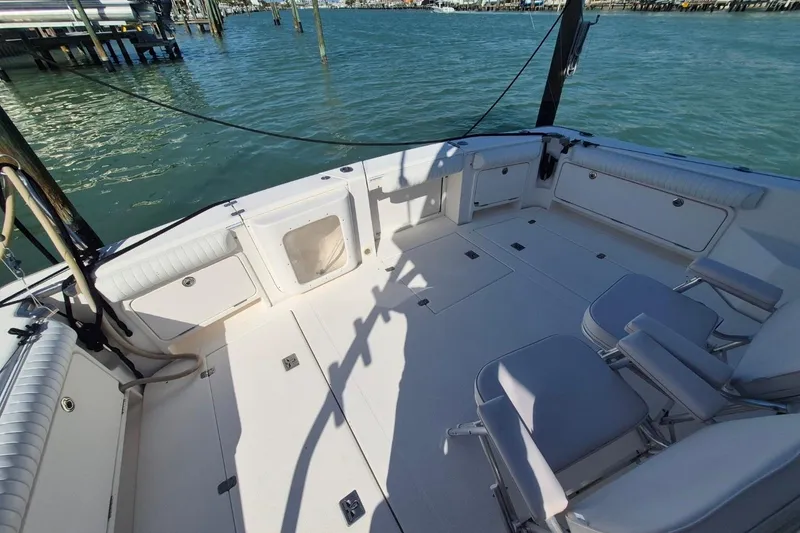 Slide: The Image of 2004 Riviera 4000 Offshore boat deck with seating, docked by the water. - 8