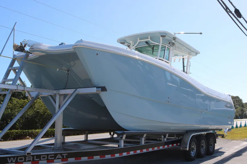 The Image of 2026 World Cat 325 CC boat on trailer, side view under clear sky. - 1