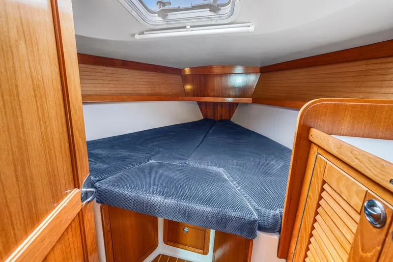 Slide: The Image of Cozy cabin interior of 2004 Catalina 36 MkII sailboat with wooden finish and blue bedding. - 20