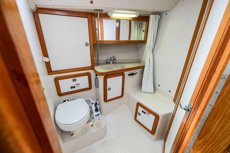 Slide: The Image of 2004 Catalina 36 MkII yacht bathroom with sink, toilet, and storage cabinets. - 22