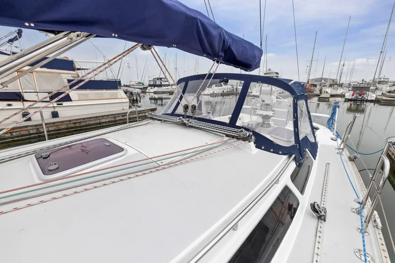 Slide: The Image of 2004 Catalina 36 MkII sailboat docked at marina, featuring spacious deck and blue canopy. - 24