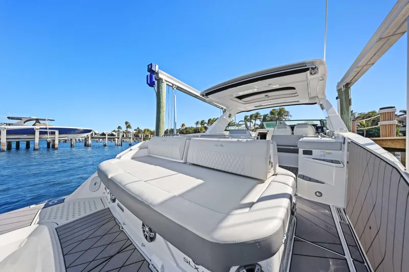 Slide: The Image of 2023 Sea Ray SLX 400 Outboard luxury boat docked, showcasing spacious seating and sleek design. - 27