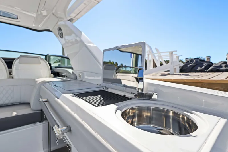 Slide: The Image of 2023 Sea Ray SLX 400 Outboard boat interior with sink and seating area. - 32