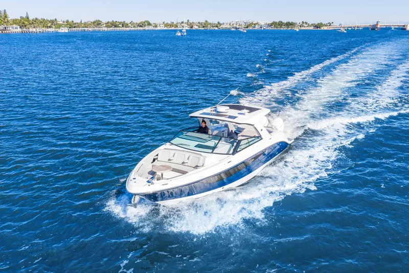Slide: The Image of 2023 Sea Ray SLX 400 Outboard cruising on clear blue water. - 11