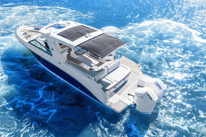 Slide: The Image of 2023 Sea Ray SLX 400 Outboard cruising on sparkling blue ocean waters. - 19