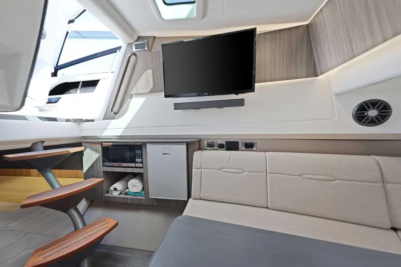 Slide: The Image of Interior of 2023 Sea Ray SLX 400 Outboard with TV, sofa, and kitchenette. - 41