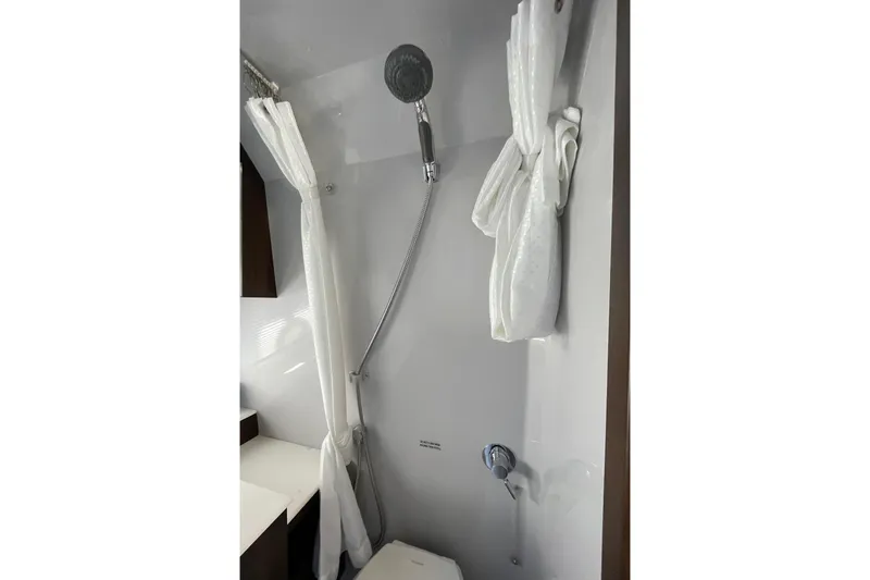 Slide: The Image of 2023 Cruisers Yachts 38 GLS I/O bathroom with shower and white curtain. - 10