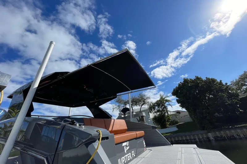 Slide: The Image of 2023 Cruisers Yachts 38 GLS I/O with canopy, docked under a clear blue sky. - 17