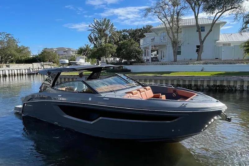 Slide: The Image of 2023 Cruisers Yachts 38 GLS I/O in a serene waterfront setting. - 2