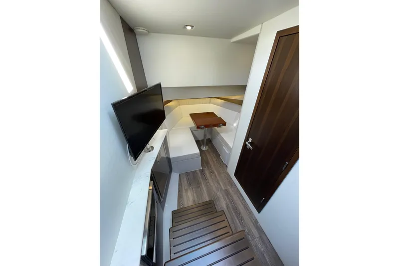 Slide: The Image of 2023 Cruisers Yachts 38 GLS I/O interior with modern seating, TV, and wooden flooring. - 22
