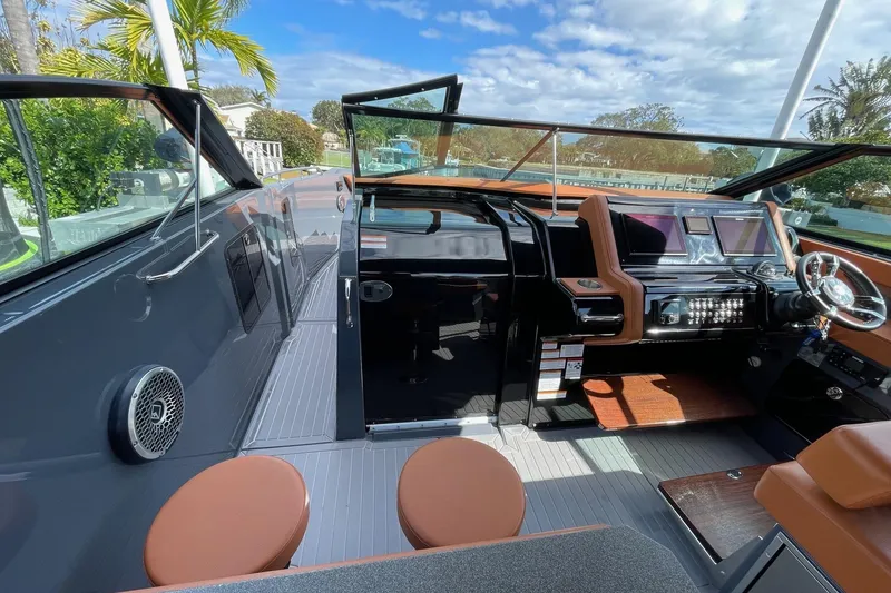 Slide: The Image of 2023 Cruisers Yachts 38 GLS I/O cockpit with modern dashboard and seating under blue sky. - 40