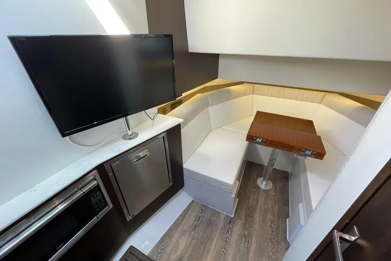 Slide: The Image of 2023 Cruisers Yachts 38 GLS I/O interior with TV, seating, and table. - 7