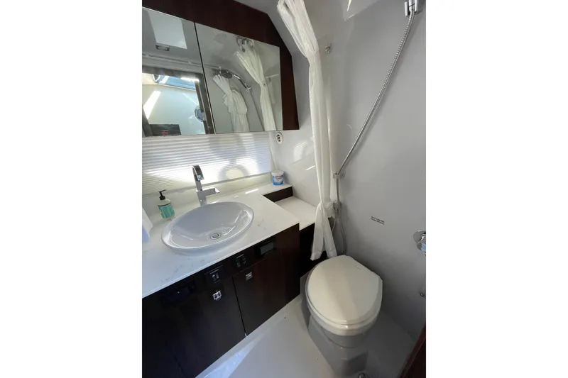 Slide: The Image of 2023 Cruisers Yachts 38 GLS I/O bathroom with sink, mirror, and toilet. - 8