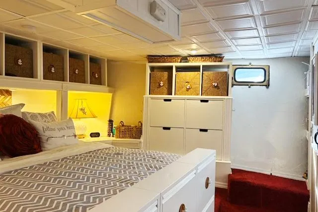 Slide: The Image of Cozy 1987 Kelly motor yacht bedroom with storage, decorative pillows, and a small window. - 29