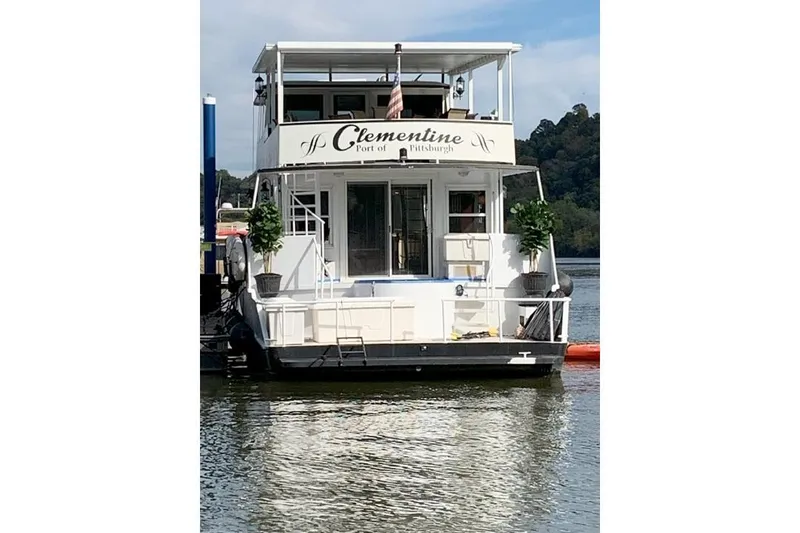 Slide: The Image of 1987 Kelly motor yacht "Clementine" docked, featuring upper deck and potted plants. - 3