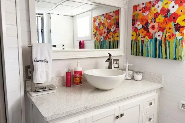 Slide: The Image of Elegant yacht bathroom with modern sink, vibrant floral artwork, and white cabinetry. - 30