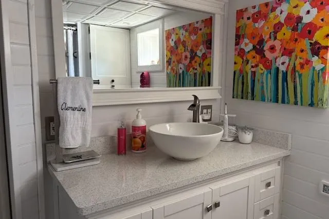 Slide: The Image of Elegant yacht bathroom with vessel sink, colorful floral artwork, and modern decor. - 33