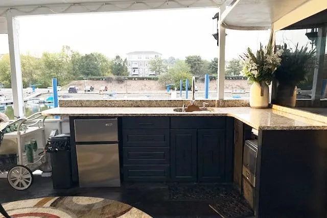 Slide: The Image of 1987 Kelly motor yacht with outdoor kitchen, granite countertops, and scenic marina view. - 40