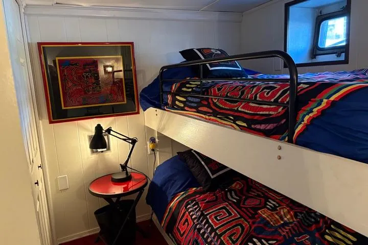 Slide: The Image of Cozy 1987 Kelly motor yacht cabin with bunk beds, vibrant bedding, and nautical decor. - 48