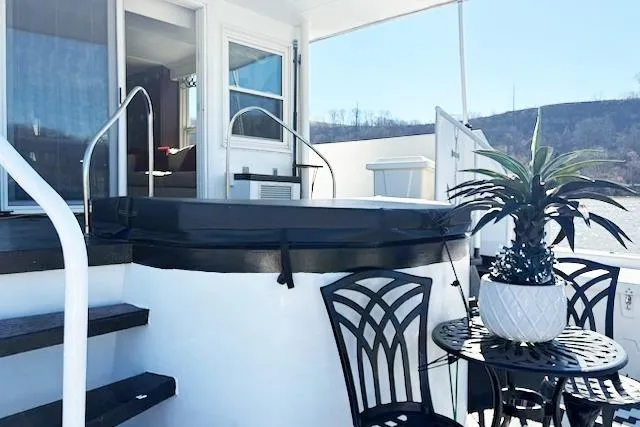 Slide: The Image of 1987 Kelly motor yacht deck with hot tub, black chairs, and potted plant. - 7