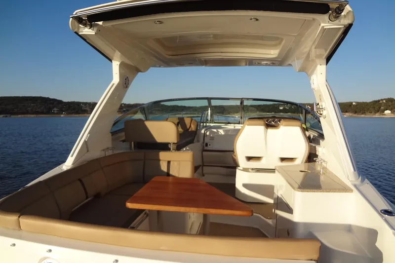 Slide: The Image of 2017 Sea Ray Sundancer 350 interior with seating and table on calm water. - 17