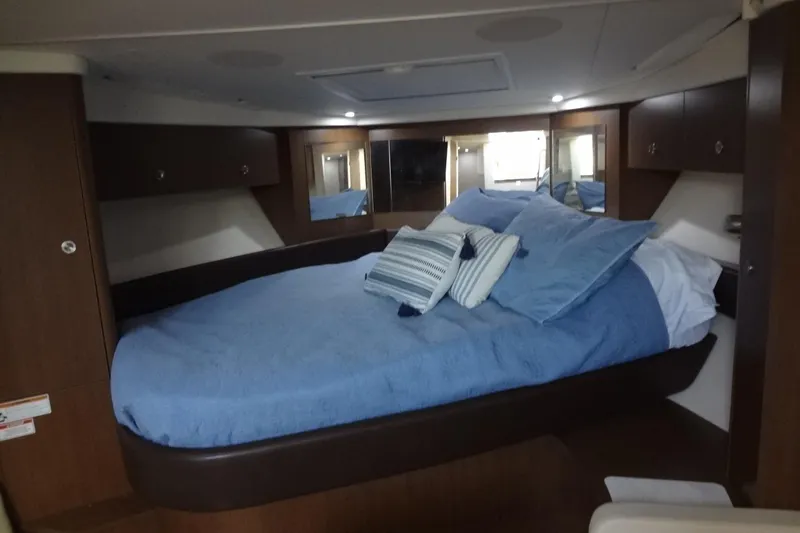 Slide: The Image of 2017 Sea Ray Sundancer 350 cabin with cozy bed and blue bedding. - 40