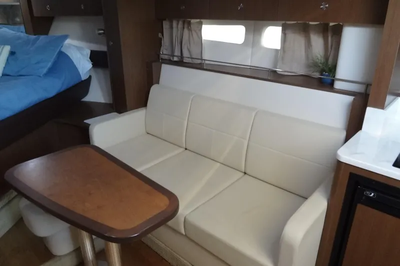 Slide: The Image of Interior of 2017 Sea Ray Sundancer 350 with beige sofa and wooden table. - 42