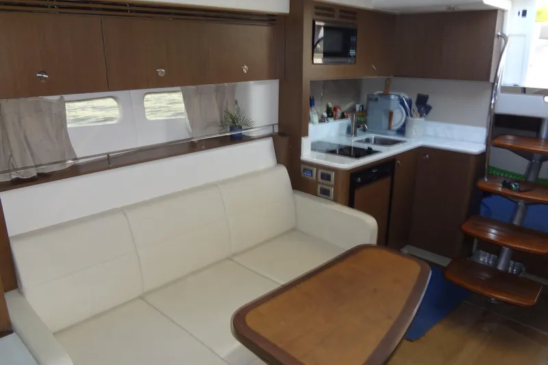 Slide: The Image of 2017 Sea Ray Sundancer 350 interior with kitchen, sofa, and wooden stairs. - 43
