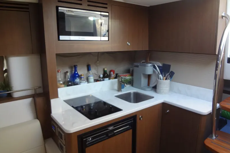 Slide: The Image of 2017 Sea Ray Sundancer 350 yacht kitchen with microwave, stove, and sink. - 44