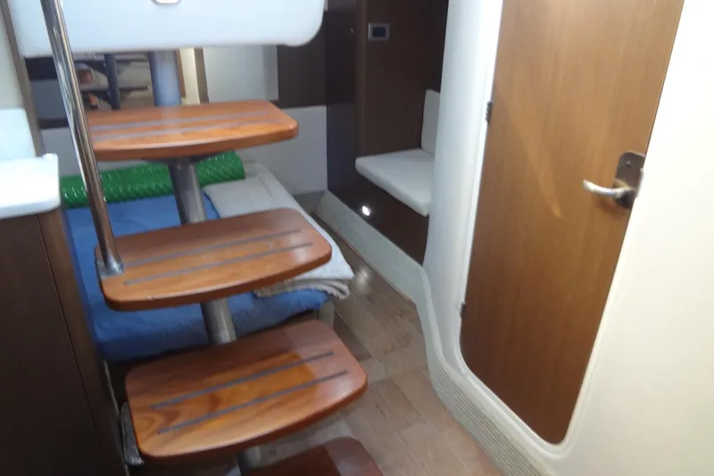 Slide: The Image of Interior of 2017 Sea Ray Sundancer 350 with wooden steps and cozy seating area. - 47