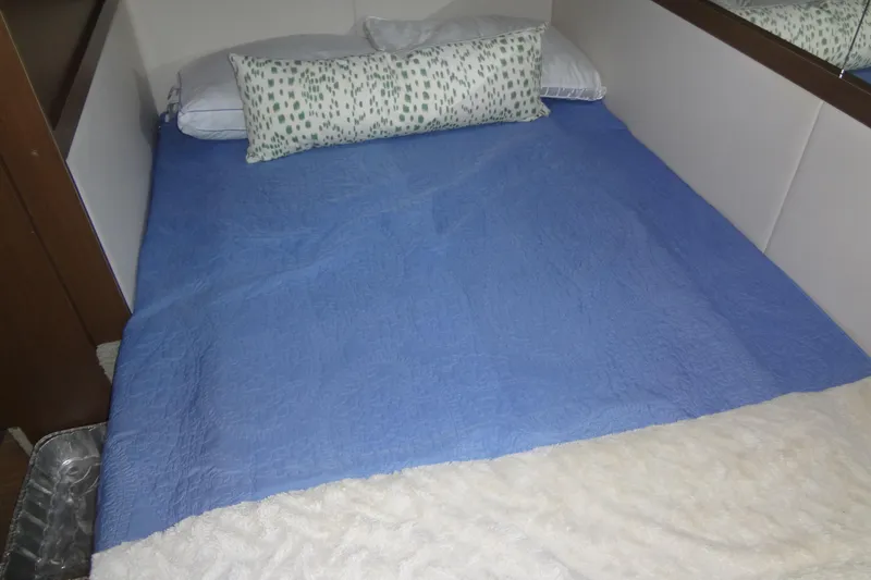 Slide: The Image of Cozy bed in 2017 Sea Ray Sundancer 350 cabin with blue cover and decorative pillow. - 49