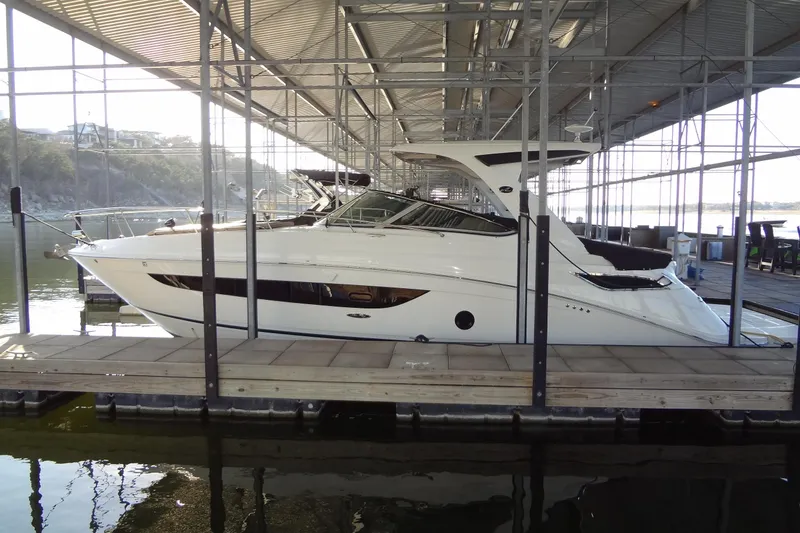 Slide: The Image of 2017 Sea Ray Sundancer 350 yacht docked in a marina under a covered structure. - 61