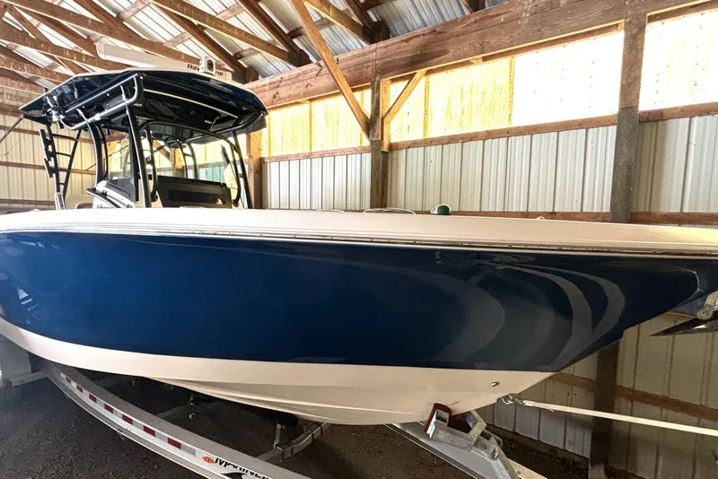The Image of 2019 Wellcraft 302 Fisherman boat in storage, blue hull, on trailer. - 1