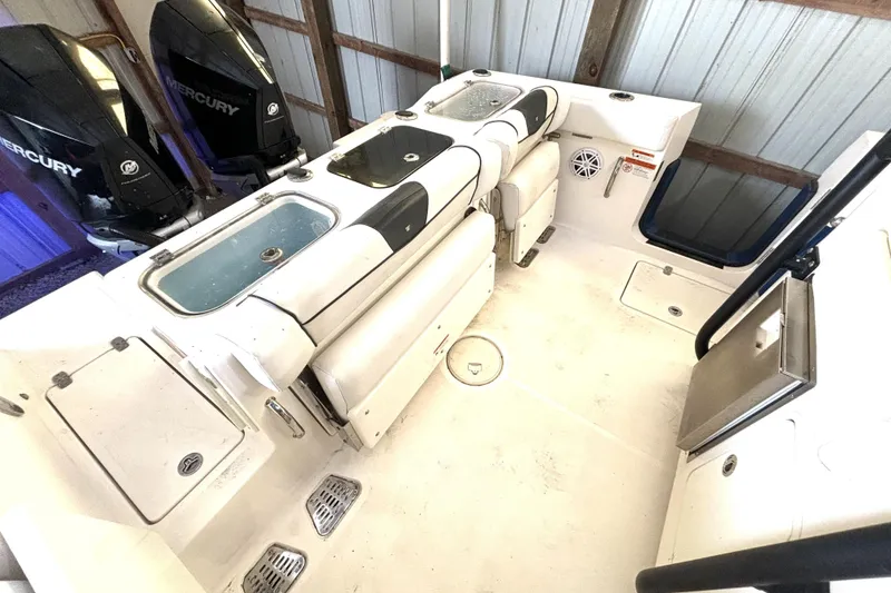 Slide: The Image of 2019 Wellcraft 302 Fisherman boat interior with Mercury engines, featuring storage and seating. - 15