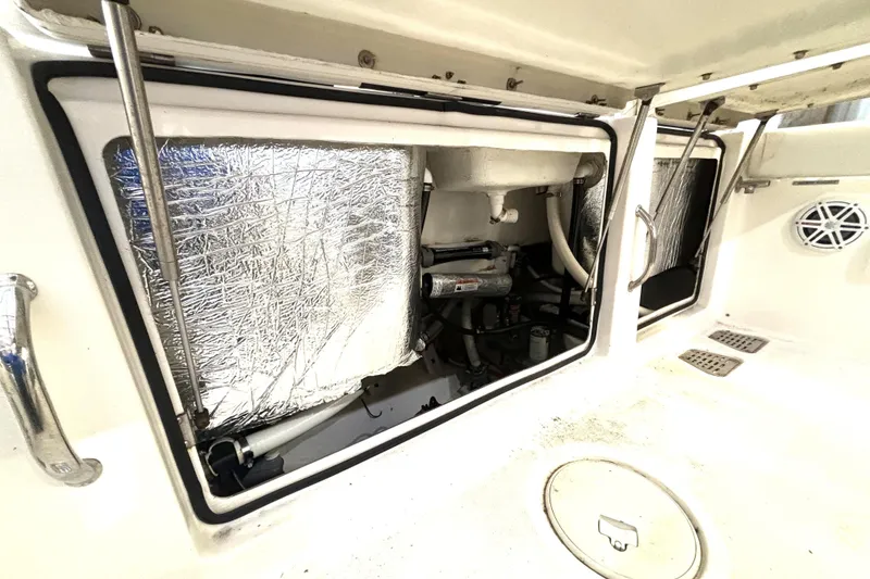 Slide: The Image of 2019 Wellcraft 302 Fisherman boat interior with open storage compartments and visible insulation. - 17