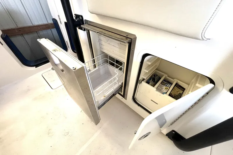 Slide: The Image of 2019 Wellcraft 302 Fisherman boat storage compartments with open doors, showcasing interior organization. - 19