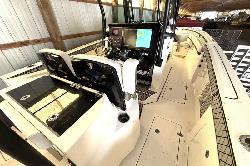 Slide: The Image of 2019 Wellcraft 302 Fisherman boat interior with dual consoles and navigation screens in a storage facility. - 20