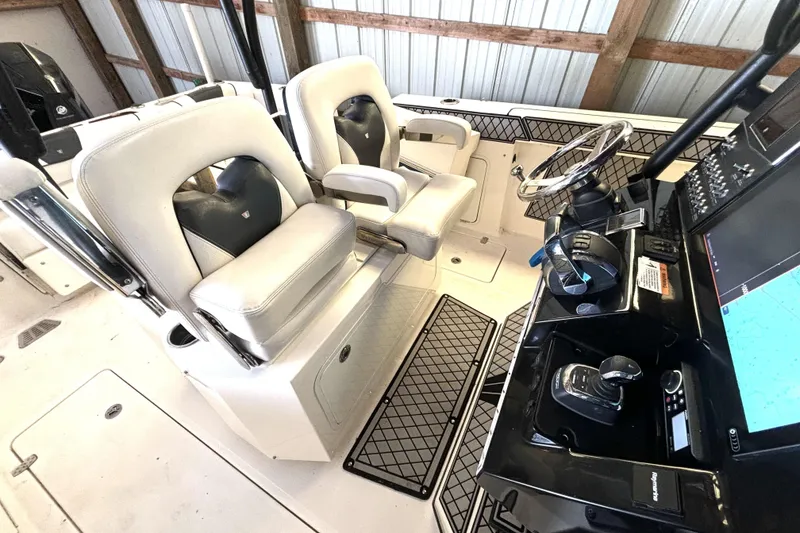 Slide: The Image of 2019 Wellcraft 302 Fisherman boat interior with helm, steering wheel, and seating. - 22