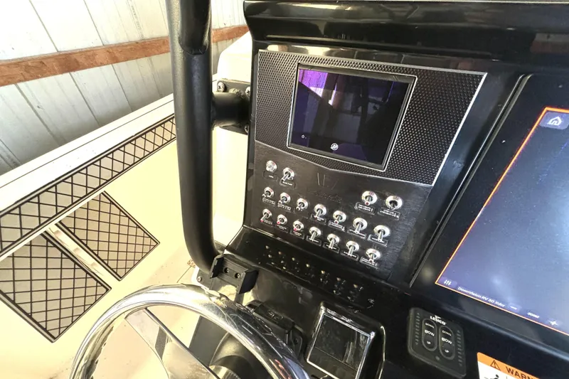Slide: The Image of Control panel of a 2019 Wellcraft 302 Fisherman boat with steering wheel and switches. - 24