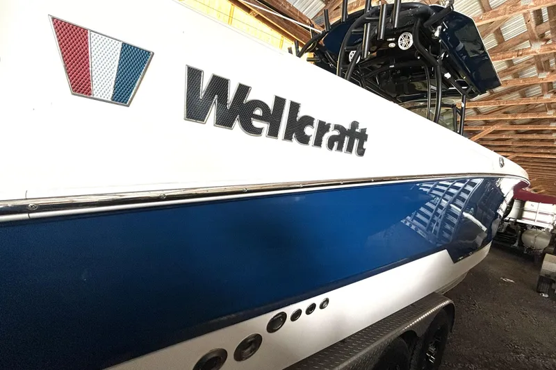 Slide: The Image of 2019 Wellcraft 302 Fisherman boat in storage, showcasing sleek blue and white design. - 3