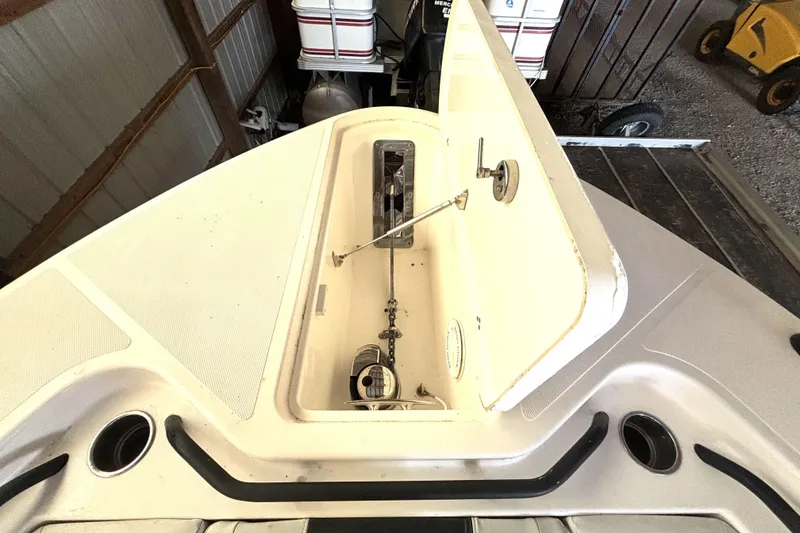Slide: The Image of 2019 Wellcraft 302 Fisherman boat storage compartment open in a garage setting. - 34