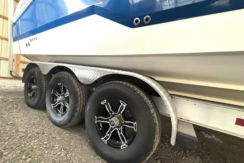 Slide: The Image of 2019 Wellcraft 302 Fisherman boat on a triple-axle trailer with stylish black wheels. - 4