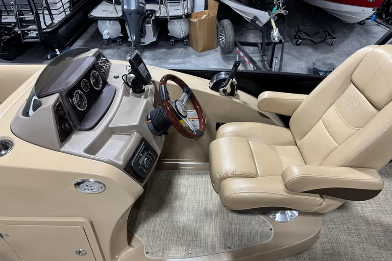 Slide: The Image of 2018 Lowe Retreat 250 RFL boat cockpit with beige captain's chair and control panel. - 11
