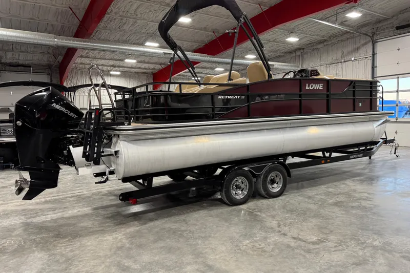 Slide: The Image of 2018 Lowe Retreat 250 RFL pontoon boat in a showroom, featuring a Mercury outboard motor. - 4