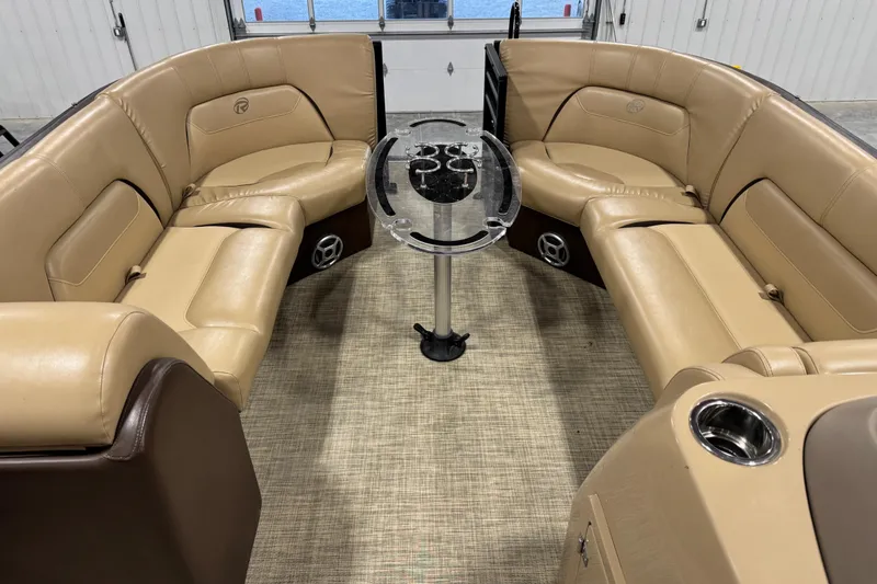 Slide: The Image of 2018 Lowe Retreat 250 RFL boat interior with tan leather seating and central table. - 7