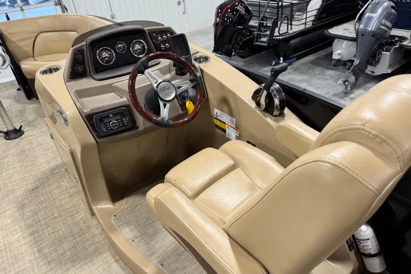 Slide: The Image of 2018 Lowe Retreat 250 RFL boat interior with beige captain's chair and control panel. - 8