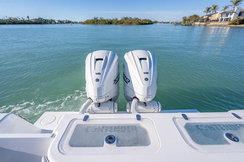 Slide: The Image of 2026 Contender 35 ST boat with twin V8 engines on a serene waterway. - 16