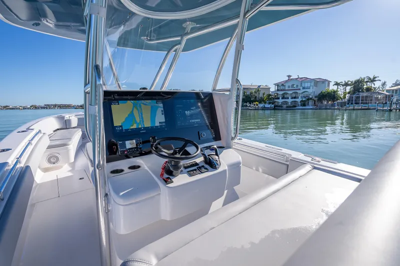 Slide: The Image of 2026 Contender 35 ST boat cockpit with advanced navigation system, docked near waterfront homes. - 18