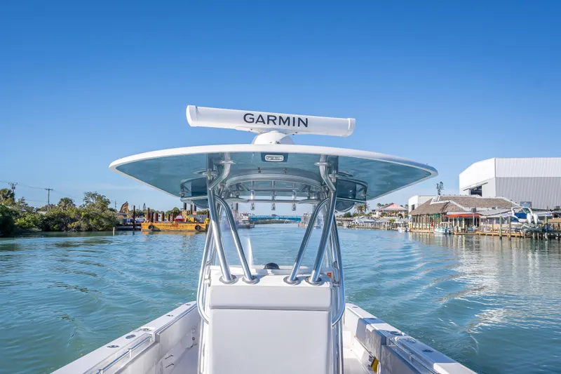 Slide: The Image of 2026 Contender 35 ST boat navigating a scenic waterway with clear blue skies. - 36